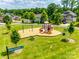 Community playground with swings, slides, and a play structure on a grassy lawn at 173 Morgans Branch Rd, Belmont, NC 28012