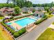 Aerial view of a community pool with lounge chairs, umbrellas, and lush landscaping at 173 Morgans Branch Rd, Belmont, NC 28012