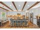 Beautiful kitchen with a stone island, barstool seating, stainless steel appliances, and wood beam ceiling at 1849 Still Water Ln, Indian Land, SC 29707