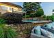 Backyard swimming pool with stone retaining wall and waterfall feature, surrounded by lush landscaping at 1849 Still Water Ln, Indian Land, SC 29707