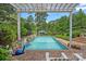Sparkling pool and basketball hoop with beautiful landscaping under a shaded pergola at 1849 Still Water Ln, Indian Land, SC 29707