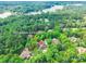 Aerial view pinpoints a luxury home address surrounded by dense trees and a glimpse of a lake at 1868 Chestnut Hill Dr, Tega Cay, SC 29708
