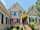 Elegant brick home featuring a well-manicured lawn, classic black shutters, and inviting front entryway at 1868 Chestnut Hill Dr, Tega Cay, SC 29708
