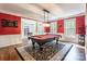 Beautiful game room with a pool table, chandelier, and red accent wall at 1868 Chestnut Hill Dr, Tega Cay, SC 29708