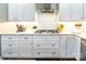 Bright kitchen featuring a gas range, white cabinetry, stainless hood, and stylish backsplash at 1868 Chestnut Hill Dr, Tega Cay, SC 29708