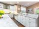Bright kitchen featuring white cabinets, granite counters, backsplash, and a stainless steel farmhouse sink at 1868 Chestnut Hill Dr, Tega Cay, SC 29708