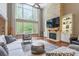 Bright living room with hardwood floors, a wall of windows, and a stone fireplace with built-ins at 1868 Chestnut Hill Dr, Tega Cay, SC 29708