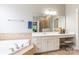 Bright primary bathroom features a large soaking tub, white double sink vanity, and full shower at 1868 Chestnut Hill Dr, Tega Cay, SC 29708