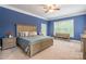 Spacious primary bedroom with wooden bed frame, ensuite access to backyard, and ceiling fan at 1868 Chestnut Hill Dr, Tega Cay, SC 29708
