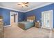 Large primary bedroom features calming blue walls, wooden bed frame, and ensuite access to backyard at 1868 Chestnut Hill Dr, Tega Cay, SC 29708
