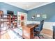 Comfortable office with blue walls, wainscoting, built-in shelves, and desk at 1868 Chestnut Hill Dr, Tega Cay, SC 29708
