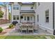 A patio with a table, chairs, a grill and view of the white home's exterior at 206 Hillside Ave, Charlotte, NC 28209