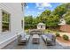 An outdoor stone patio features seating, a table, and view of the well maintained yard and a backyard shed at 206 Hillside Ave, Charlotte, NC 28209