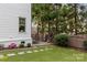 The backyard features green grass, landscaping, a play area and brick fencing at 206 Hillside Ave, Charlotte, NC 28209