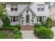 Elegant home entrance with arched doorway, brick steps, and lush, manicured landscaping at 206 Hillside Ave, Charlotte, NC 28209