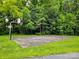 Outdoor basketball court surrounded by a green lawn and mature trees at 2065 Gable Way Ln, Matthews, NC 28104