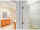 Bright bathroom featuring wooden cabinets, neutral walls, and an adjacent closet with wire shelving at 2065 Gable Way Ln, Matthews, NC 28104