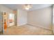 Spacious carpeted bedroom with neutral walls and a ceiling fan, leading to an en-suite bathroom at 2065 Gable Way Ln, Matthews, NC 28104