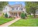 Charming two-story home with black shutters, a covered porch, and a well-manicured lawn at 2065 Gable Way Ln, Matthews, NC 28104