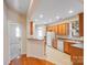 Cozy kitchen with wood cabinetry, white appliances, and an adjacent breakfast bar at 2065 Gable Way Ln, Matthews, NC 28104
