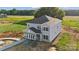 Newly built two-story home featuring gray siding, black roof, and a welcoming covered entryway at 21047 Running Creek Dr # 9, Locust, NC 28097