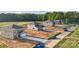 New construction homes line a street showcasing the neighborhood's layout and surrounding wooded area at 21055 Running Creek Dr # 10, Locust, NC 28097