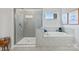 Modern bathroom with tiled shower, soaking tub, and ample natural light at 21055 Running Creek Dr # 10, Locust, NC 28097