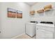 Laundry room with modern washer and dryer, overhead shelving and decor at 21055 Running Creek Dr # 10, Locust, NC 28097