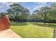 Large grassy backyard with mature trees and wooden steps leading to the back door at 214 Silver Creek Ln, Shelby, NC 28152