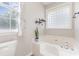 Bright bathroom featuring a soaking tub and decorative window at 214 Silver Creek Ln, Shelby, NC 28152