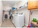 Functional laundry room with modern washer and dryer, shelving, and tile flooring at 214 Silver Creek Ln, Shelby, NC 28152
