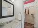 Bright bathroom with marble vanity and decorative mirror adjoins walk-in closet with custom shelving at 2315 Selwyn Ave # F, Charlotte, NC 28207