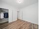 Bedroom features hardwood floors, closet with clothes, white trim, and neutral walls at 2315 Selwyn Ave # F, Charlotte, NC 28207