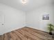 Empty bedroom with hardwood floors, white walls, trim and bright overhead lighting at 2315 Selwyn Ave # F, Charlotte, NC 28207