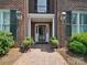 Inviting brick home entrance with decorative lanterns, potted plants, and a charming brick walkway at 2315 Selwyn Ave # F, Charlotte, NC 28207