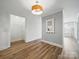 Bright hallway with wood floors, white trim, and modern lighting, with an open doorway at 2315 Selwyn Ave # F, Charlotte, NC 28207