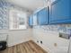 Laundry Room featuring blue cabinets, floral wallpaper and bead board at 2315 Selwyn Ave # F, Charlotte, NC 28207