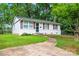 A charming single-story home boasts fresh paint, shutters, landscaping and a paved walkway to the front door at 2328 Danforth Ln, Charlotte, NC 28208