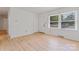 Bright living room boasts wood floors, a window bringing in natural light, and access to the front door at 2328 Danforth Ln, Charlotte, NC 28208