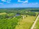 Aerial view of the property showcasing the home's location, surrounding greenery, lake, and access road at 2410 Charlotte Hwy, York, SC 29745
