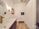Chic bathroom features a modern vanity with gold accents, a round mirror, and a shower with a white curtain at 2410 Charlotte Hwy, York, SC 29745