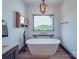 Bright bathroom with soaking tub, decorative lighting, and large window with a scenic view at 2410 Charlotte Hwy, York, SC 29745