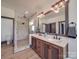 Bathroom featuring a glass shower, dual sinks, wood cabinets, and stone countertops at 2410 Charlotte Hwy, York, SC 29745