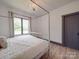 Bright bedroom showcases a four-poster bed, large window with curtains, and hardwood floors at 2410 Charlotte Hwy, York, SC 29745