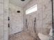 Modern shower featuring elegant marble tiling, black fixtures, and unique pebble flooring, providing a spa-like experience at 2410 Charlotte Hwy, York, SC 29745