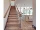 Open staircase with carpeted steps leading to a well-lit kitchen area with a center island at 2410 Charlotte Hwy, York, SC 29745