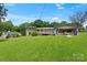 Expansive backyard featuring a deck, carport, and lush green lawn perfect for outdoor activities at 245 Enwood Dr, Charlotte, NC 28214