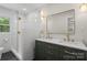 Elegant bathroom features a glass enclosed shower, double vanity with gold fixtures, and dark floors at 245 Enwood Dr, Charlotte, NC 28214