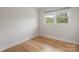 Inviting bedroom features hardwood floors and a window with bright sunlight, ideal for relaxation at 245 Enwood Dr, Charlotte, NC 28214