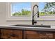 Modern kitchen sink with a matte black faucet and wooden cabinets, complemented by a view from the window at 245 Enwood Dr, Charlotte, NC 28214